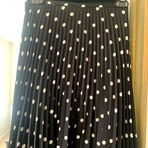 Mid length black and white polka dot pleated skirt. Size 8.